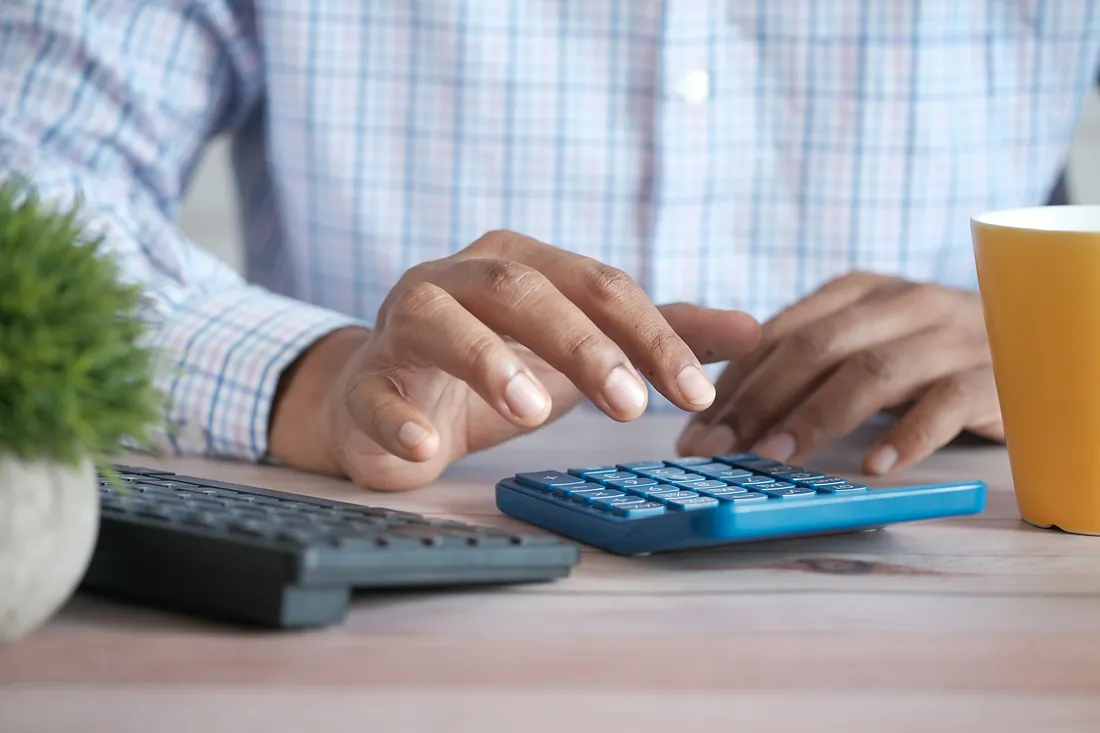Person calculating at a desk - tax law Person calculating at a desk - tax law