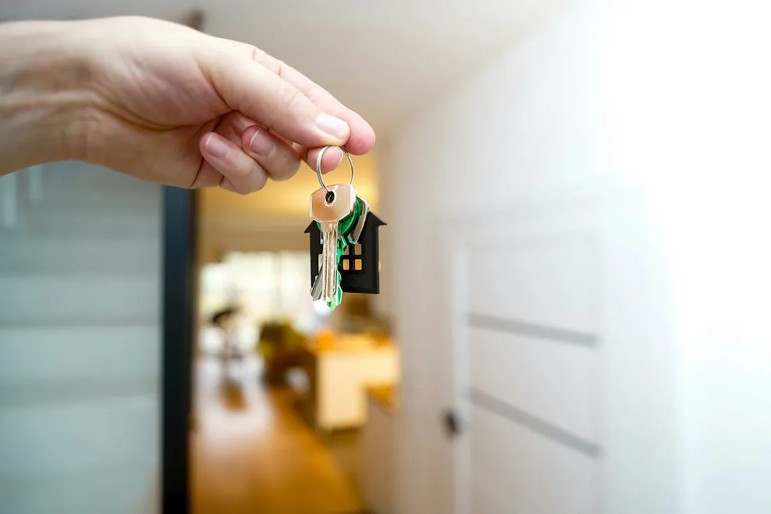Hand holding house keys - real estate law Hand holding house keys - real estate law